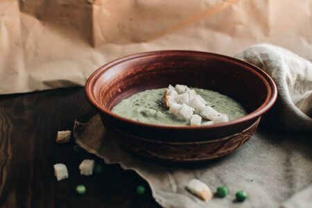 Green cream vegetable soup broccoli, peas, zucchini, spinach with croutons. Delicious vegetarian healthy food.の写真素材
