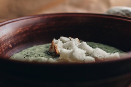 Green cream vegetable soup broccoli, peas, zucchini, spinach with croutons. Delicious vegetarian healthy food.の写真素材