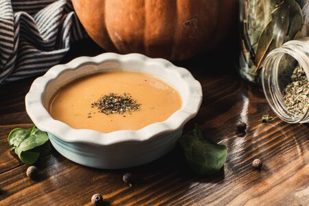 Pumpkin and carrot cream soup on dark wooden background. Pumpkin. Thanksgiving concept.の写真素材