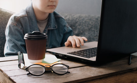 Teenage boy works at desk in his bedroom. School and work concept. Home education. Homework. Home schooling. Working at home. の写真素材