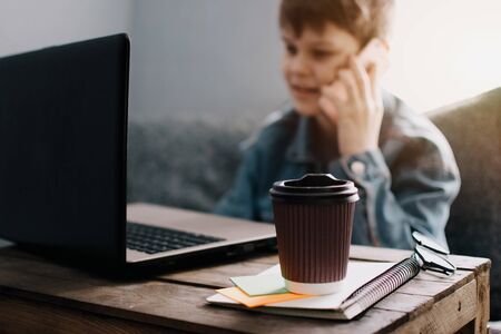 Teenage boy works at desk in his bedroom. School and work concept. Home education. Homework. Home schooling. Working at home.の写真素材