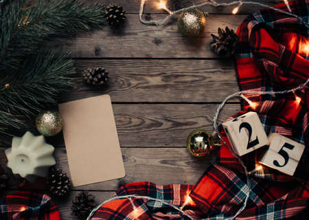 Christmas background with fir tree and decoration on dark wooden board. Christmas mood. Flat lay winter cozy vintage background. Vintage paper with copy space; overhead view.の写真素材
