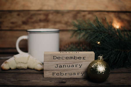 Wooden blocks against a rustic wood background with Christmas tree, Santa Claus and lights. Background with christmas decor. Christmas background. Winter months.の写真素材