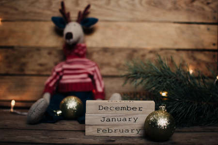 Wooden blocks against a rustic wood background with Christmas tree, Santa Claus and lights. Background with christmas decor. Christmas background. Winter months.の写真素材