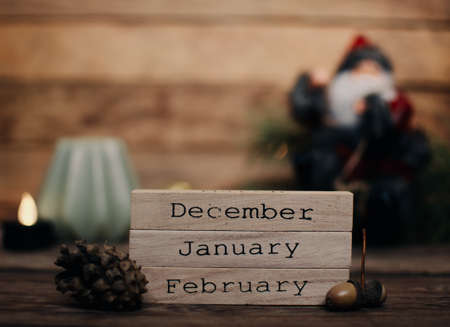 Wooden blocks against a rustic wood background with Christmas tree, Santa Claus and lights. Background with christmas decor. Christmas background. Winter months.の写真素材