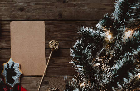 Christmas background with fir tree and decoration on dark wooden board. Christmas mood. Flat lay winter cozy vintage background. Vintage paper with copy space; overhead view.の写真素材