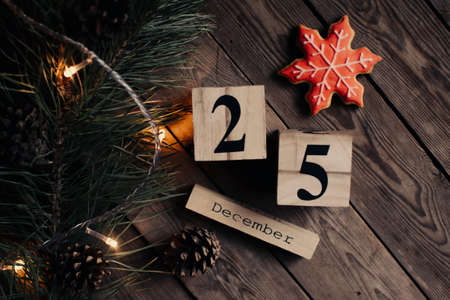 Wooden blocks against a rustic wood background with Christmas tree, cookies, cup of tea or coffee and lights. Background with christmas decor. Christmas background. Winter months.の写真素材