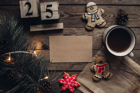 Wooden blocks against a rustic wood background with Christmas tree, cookies, cup of tea or coffee and lights. Background with christmas decor. Christmas background. Winter months.の写真素材
