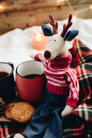 Two mugs with hot drink. Cozy festive mood. Wooden background. Christmas deer.の写真素材