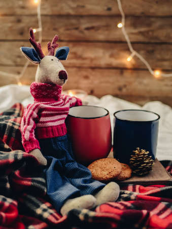 Two mugs with hot drink. Cozy festive mood. Wooden background. Christmas deer.の写真素材
