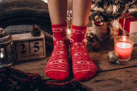 Kid`s feet in Christmas socks. Close up on feet. Winter and Christmas holidays concept. Cozy scene. Background with christmas decor. Christmas background.の写真素材