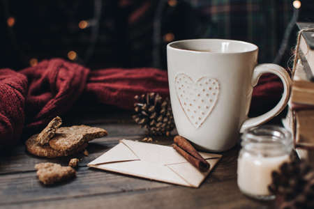 Scandinavian hygge styled Christmas composition. Cozy winter homely scene with books, cup of tea or coffee, cookies, cinnamon sticks and knitted things. Santa Claus working place. Flatlay. Home decor.の写真素材