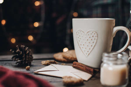 Scandinavian hygge styled Christmas composition. Cozy winter homely scene with books, cup of tea or coffee, cookies, cinnamon sticks and knitted things. Santa Claus working place. Flatlay. Home decor.の写真素材