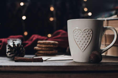 Scandinavian hygge styled Christmas composition. Cozy winter homely scene with books, cup of tea or coffee, cookies, cinnamon sticks and knitted things. Santa Claus working place. Flatlay. Home decor.の写真素材