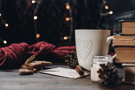 Scandinavian hygge styled Christmas composition. Cozy winter homely scene with books, cup of tea or coffee, cookies, cinnamon sticks and knitted things. Santa Claus working place. Flatlay. Home decor.の写真素材