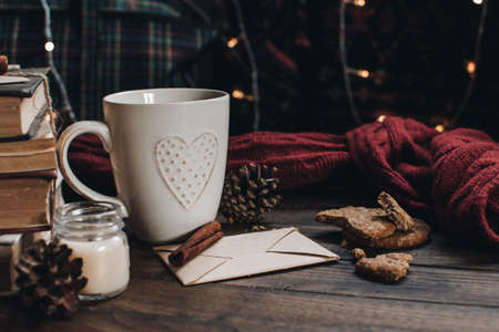 Scandinavian hygge styled Christmas composition. Cozy winter homely scene with books, cup of tea or coffee, cookies, cinnamon sticks and knitted things. Santa Claus working place. Flatlay. Home decor.の写真素材