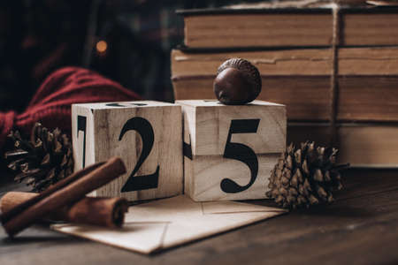 Wooden calendar blocks. Scandinavian hygge styled Christmas composition. Cozy winter homely scene with books, cinnamon sticks and knitted things. Santa Claus working place. Flatlay. Home decor.の写真素材