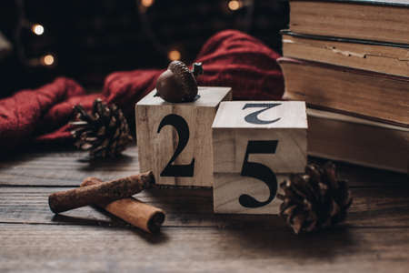 Wooden calendar blocks. Scandinavian hygge styled Christmas composition. Cozy winter homely scene with books, cinnamon sticks and knitted things. Santa Claus working place. Flatlay. Home decor.の写真素材