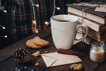 Scandinavian hygge styled Christmas composition. Cozy winter homely scene with books, cup of tea or coffee, cookies, cinnamon sticks and knitted things. Santa Claus working place. Flatlay. Home decor.の写真素材