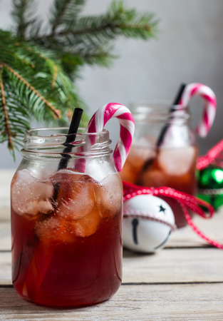 Red Christmas cocktail with candy cane and ice in mason jar. Selective focusの写真素材