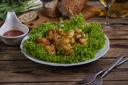 Freshly prepared breaded cauliflower in bowl with tkemali to dip. Selective Focus.の写真素材