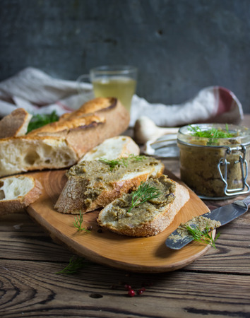 Eggplant pate in a jar and sandwiches on a wooden background. Selective focusの写真素材