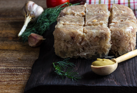 National cuisine. Russian traditional dish - Holodets. Homemade jellied meat with garlic and spices garnished with mustard. Selective focusの写真素材