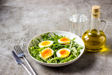 Spring salad with fresh vegetables: arugula, egg, and sesame on a gray grunge background. Selective focusの写真素材