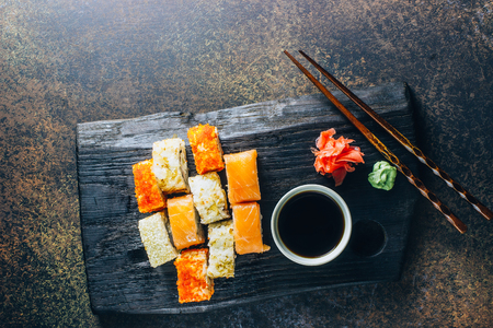 Japanese cuisine california roll and tuna roll on black wooden board served with wasabi and soy sauceの写真素材