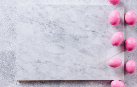 Stylish Frame background with pink decorative wooden easter eggs with copy space for text. isolated on white marble background. Flat lay, top view. Easter conceptの写真素材