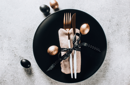 Easter table setting with black and bronze-colored decorative wooden eggs. Top viewの写真素材