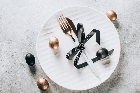 Easter table setting with black and bronze-colored decorative wooden eggs. Top viewの写真素材