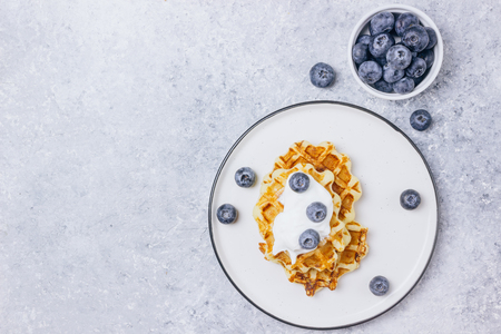 Fresh homemade Belgian waffles with blueberries for breakfast on woodenの写真素材
