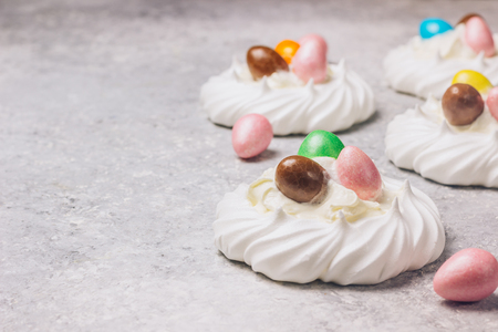 Pavlova cake decorated colored chocolate Easter egg candy. Selective focus Copy spaceの写真素材