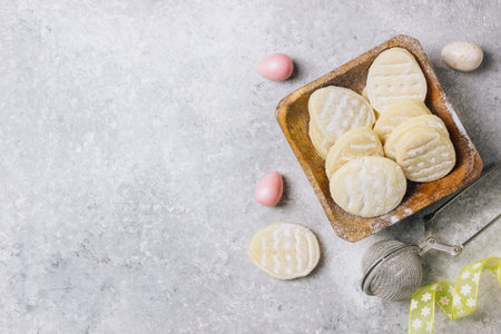 sugar easter cookies with colorful chocolate shape of eggs candy on grey background. Top view