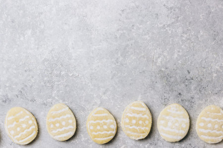 sugar easter cookies with colorful chocolate shape of eggs candy on grey background. Top view