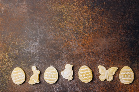Sugar easter cookies with colorful chocolate shape of eggs candy on darkの写真素材
