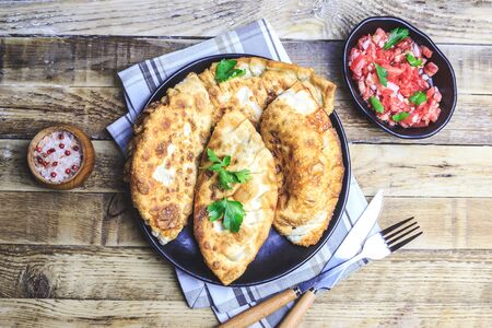 Latin American homemade fried empanadas with tomato sauces on wooden background. Top view.の写真素材