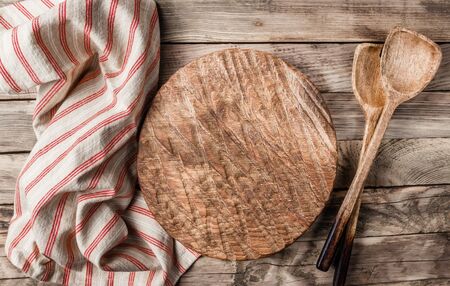 Vintage Table setting with napkin and wooden cutting board on old rustic wooden table. Top view. Copy space