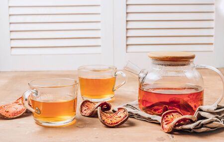 Bael fruit juice or quince tea and dried bael sliced fruit on rustic background. Thai or Asian healthy drink. Bael is helping the body to resist catching a cold. Selective focusの写真素材