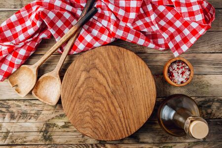 Cooking utensils, red checkered towel, bottle of oil and salt on rustic wooden table. Top view. Flat lay. Place for your textの写真素材