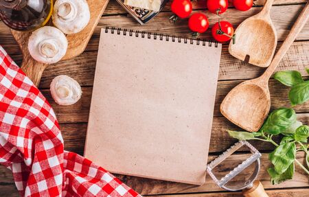 Cooking utensils and ingredients for Italian Cuisine on wooden table. Top view with blank notebookの写真素材