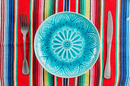 Blue plate and cutlery with colorful napkinの写真素材