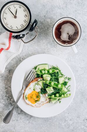 Healthy breakfast with eggs and cucumber salad with coffee on light gray background. Flat lay, top view. Minimal conceptの写真素材