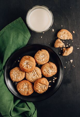 Gluten free homemade oatmeal cookies and oat milk on a dark background. Top view. Vertical photoの写真素材