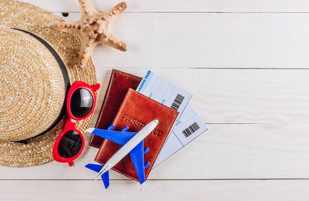 Boarding pass in in passport and toy airplane on white wooden background. Top view. Flat layの写真素材
