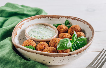 Bowl of falafel with tzatziki sauce on a white wooden table. Selective focusの写真素材