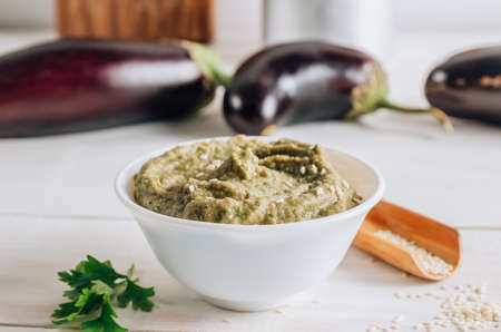Traditional arabian eggplant dip baba ganoush on white wooden table. Selective focusの写真素材