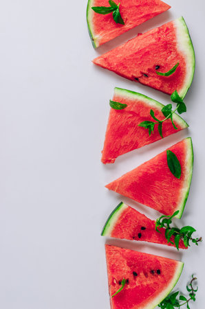 Top view of watermelon slices and mint leaves on white background. Flat lay
