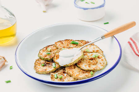 Homemade breaded zucchini with garlic sauce on a white table. selective focusの写真素材